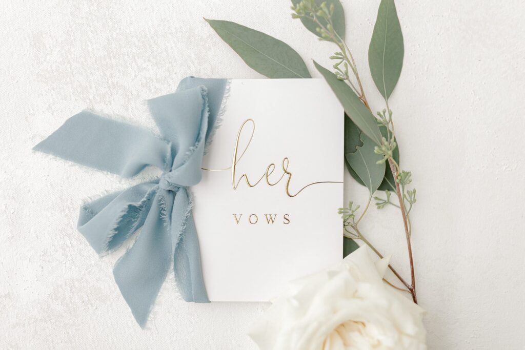 Wedding details including rings, flowers, and invitations at Mackenzie & Russell’s Shelbyville Michigan Bay Pointe Inn wedding