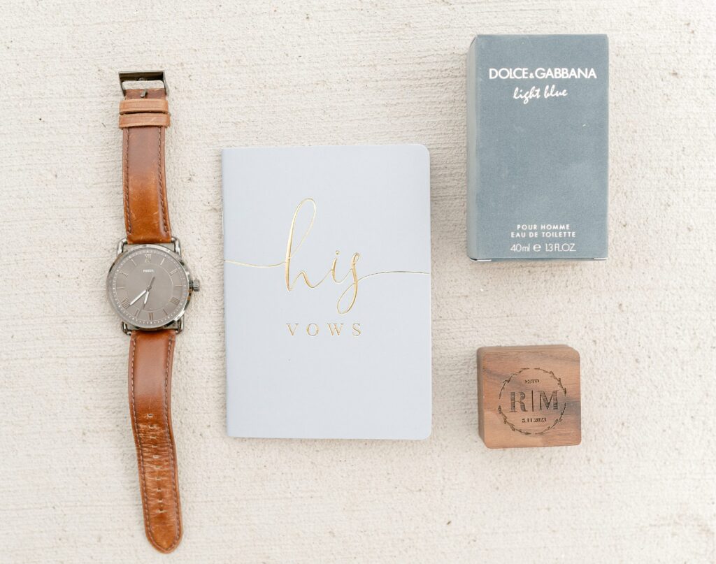 Wedding details including rings, flowers, and invitations at Mackenzie & Russell’s Shelbyville Michigan Bay Pointe Inn wedding