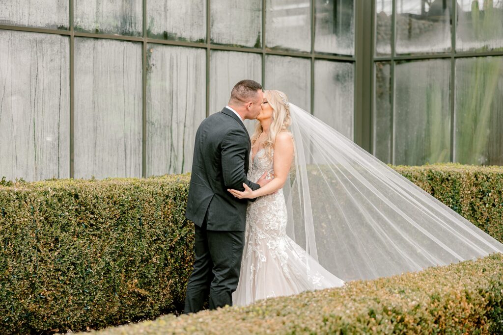 bride and groom kiss outside of Planterra Conservatory wedding venue