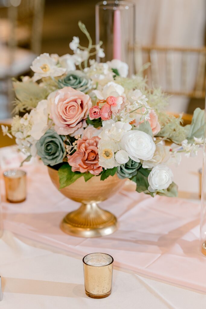 Blush and white floral centerpiece in a gold vase