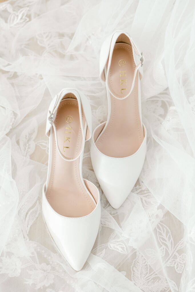 White bridal heels resting on lace