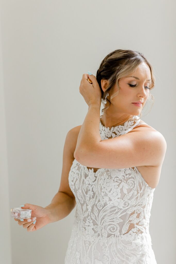 Bride putting on her earrings on her wedding morning in Grand Rapids