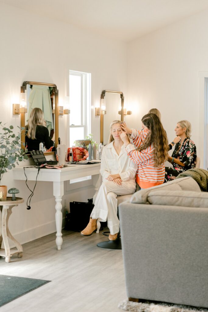 Bride getting her hair done in the bright bridal suite at Ivy House