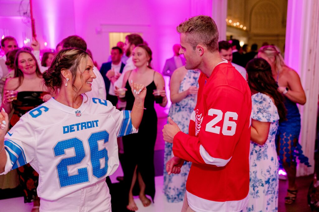 Bride and groom dancing in sports jerseys at their Grand Rapids wedding reception