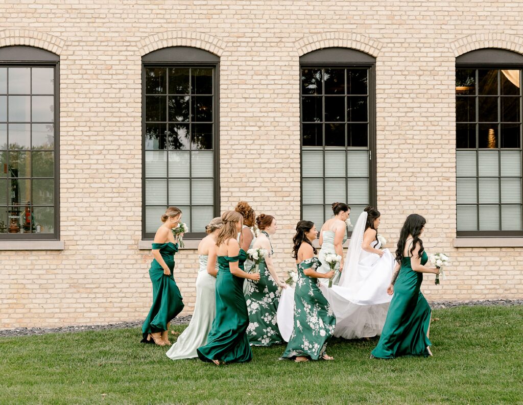 Bride with her bridesmaids in emerald green dresses on the lawn at The BRIX on Fox