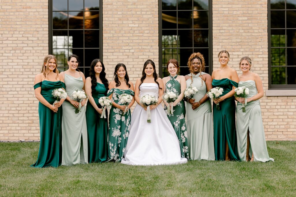 Bride with her bridesmaids in mismatched green dresses