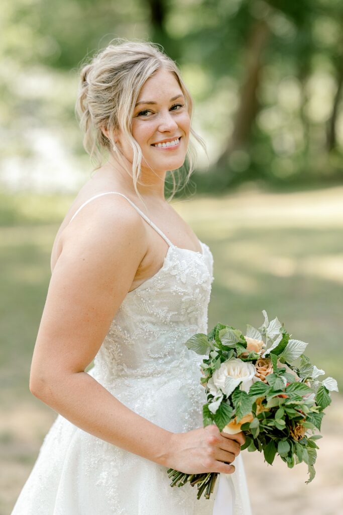 Bride holding her bouquet by the lake