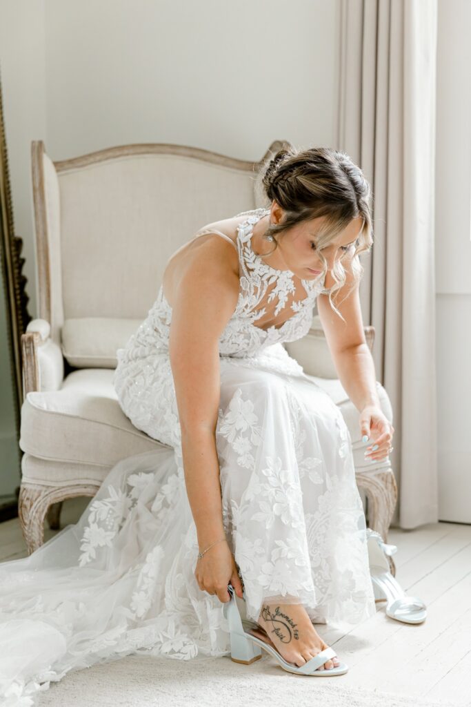 Bride putting on her wedding shoes in the bridal suite