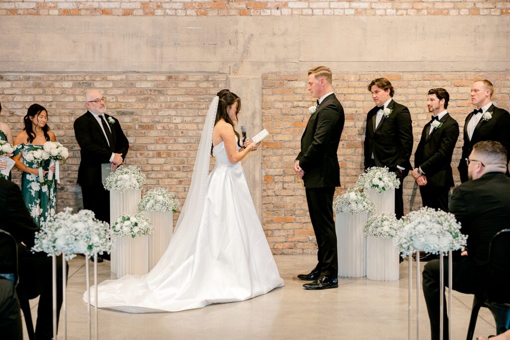 Bride and groom at the altar in front of brick walls at The BRIX on Fox