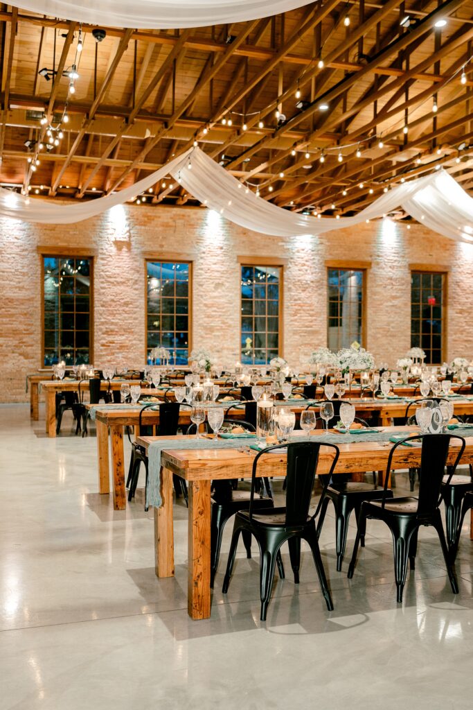 Reception space at The BRIX on Fox with long wooden tables and draped ceiling