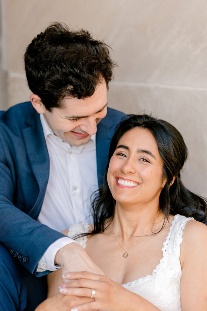 Engaged couple laughing while sitting on the Civic Auditorium steps in downtown Grand Rapids