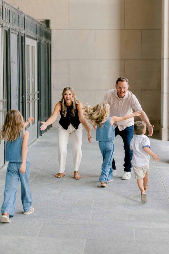 Candid family photo of kids running ahead of their parents along the Civic Auditorium walkway in Grand Rapids