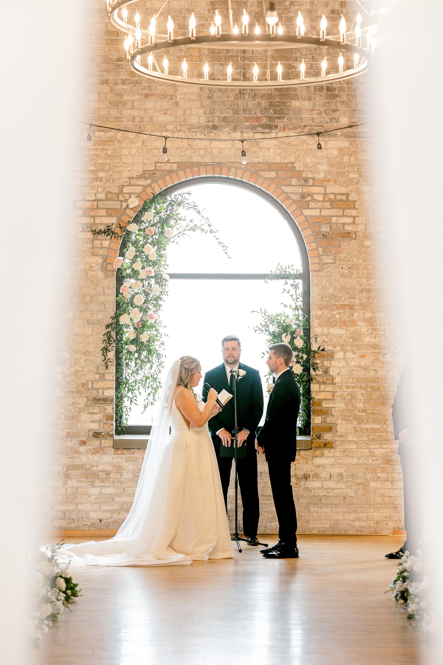 Bride and groom at the altar in front of the arched window