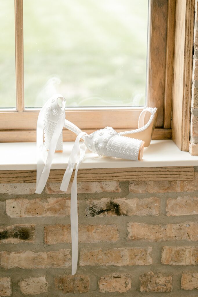 Champagne bottle wrapped in white ribbon on a brick windowsill