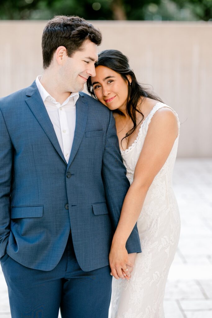 Fiancée resting her head on her partner's shoulder during a city engagement session in Grand Rapids