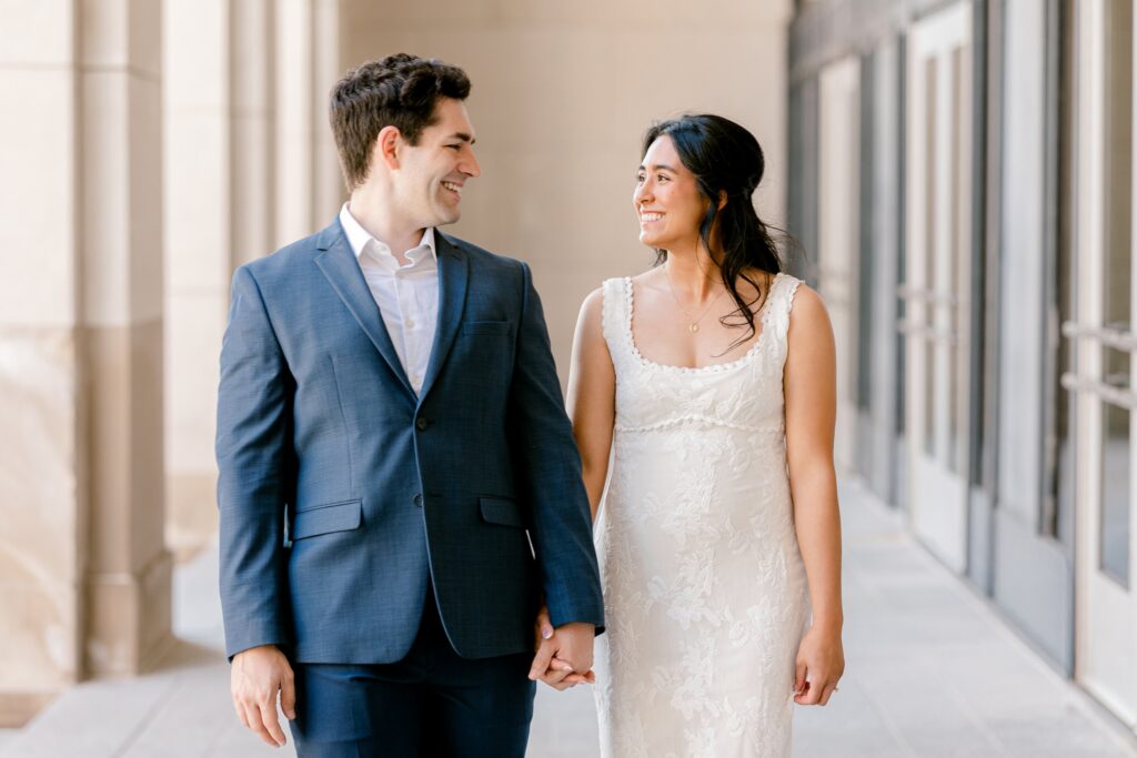 Close portrait of an engaged couple looking at each other under the stone colonnade in Grand Rapids