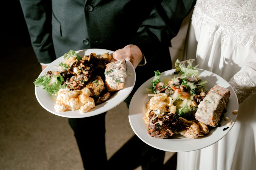 Bride and groom holding their dinner plates from Coastal Reserve