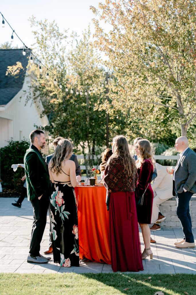 Guests gathered around a rust cocktail table on the Ivy House patio