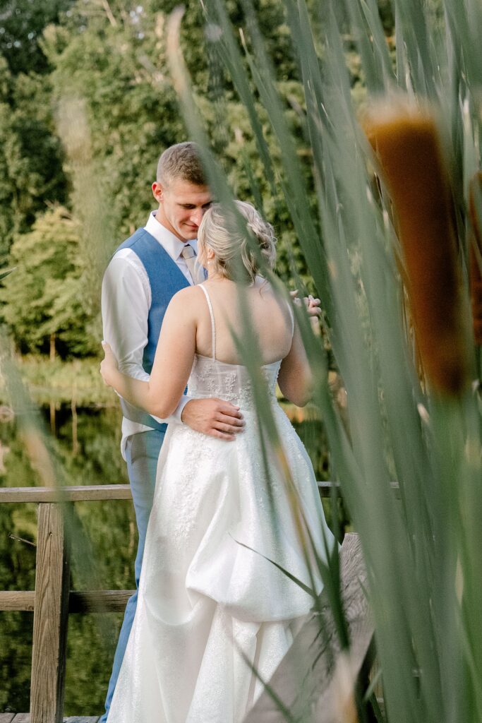 Bride and groom among the cattails by the lake