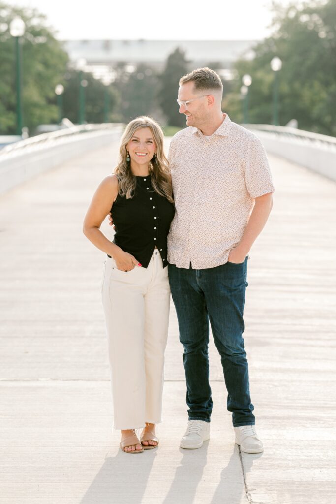 Mom and dad smiling together on the Gillett Bridge walkway during their Grand Rapids family session