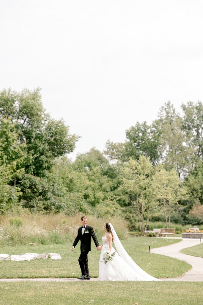 Bride and groom walking along a garden path