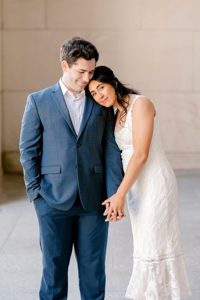 Couple leaning into each other in the Civic Auditorium colonnade during their Grand Rapids engagement session