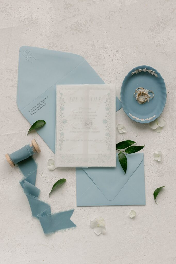 Dusty blue wedding invitation suite styled with ribbon and wax seal