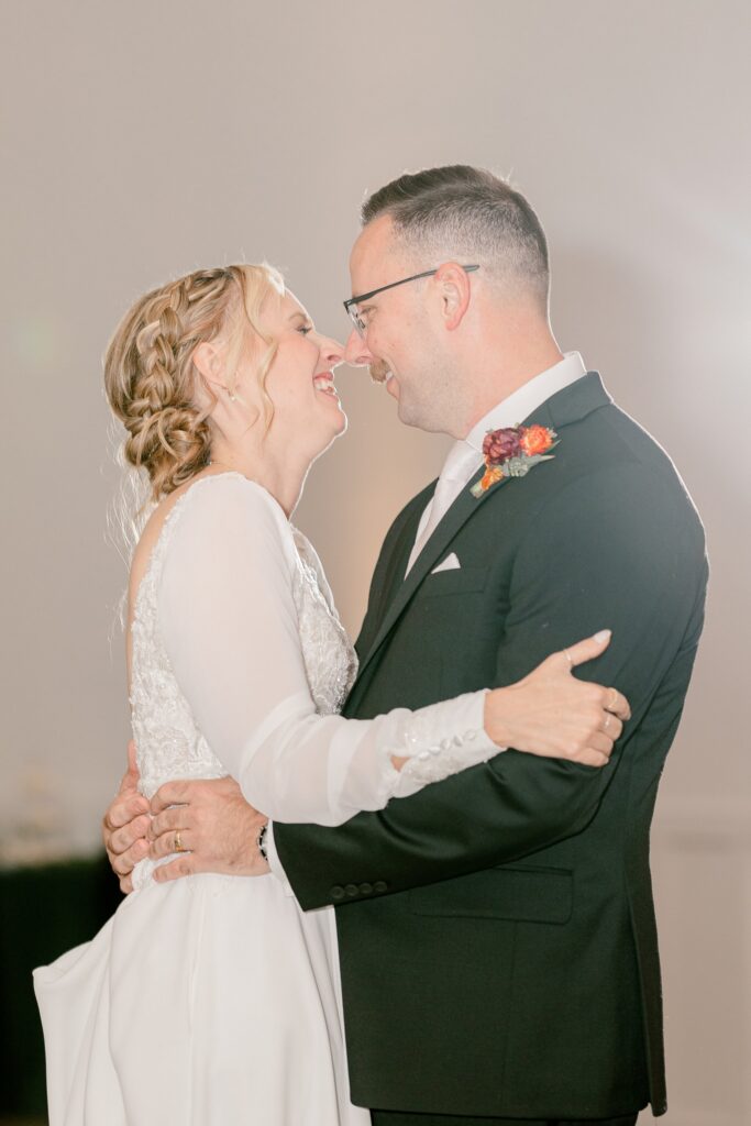 Bride and groom smiling at each other during their first dance