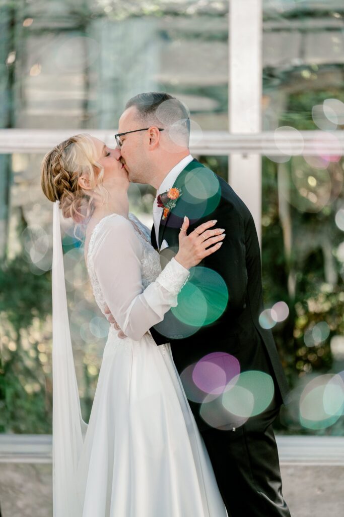 Bride and groom's first kiss in the greenhouse