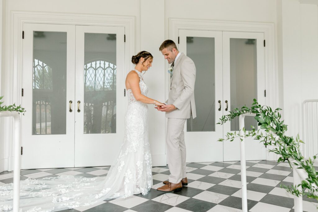 Bride and groom sharing a first look in the white room with checkered floors at The Broadway Avenue