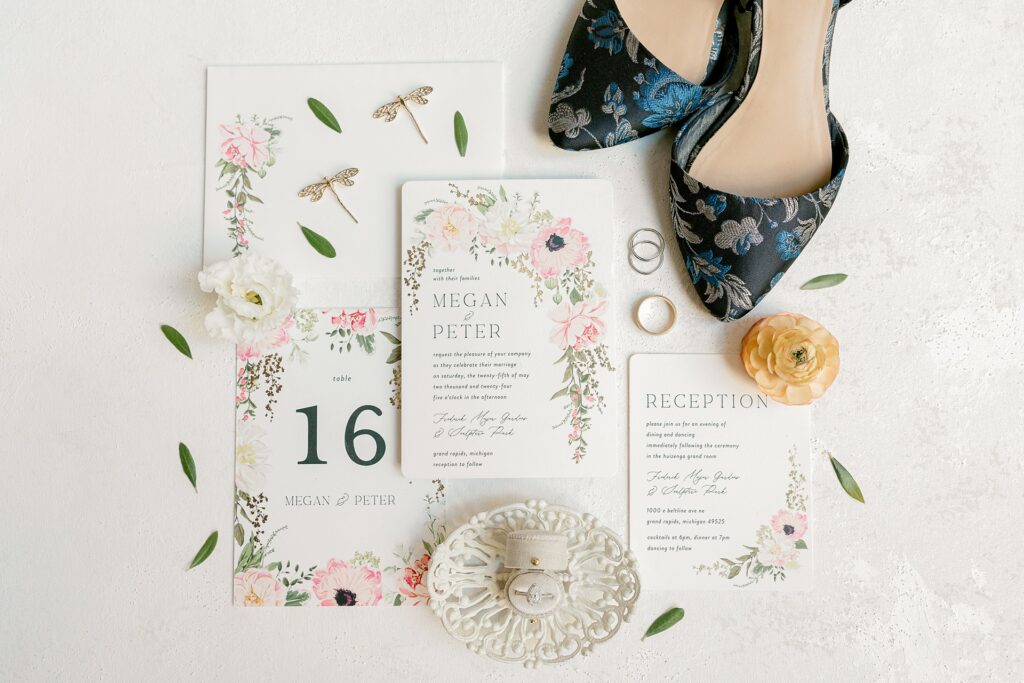 Watercolor floral wedding invitation flat lay with bridal shoes