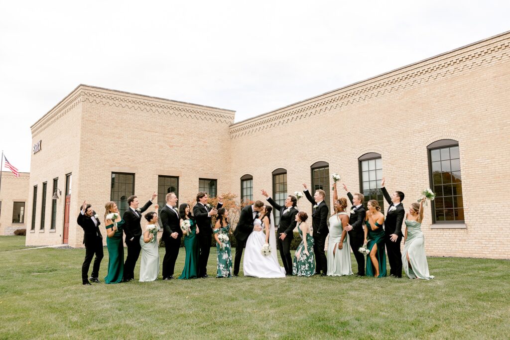 Full wedding party outside the brick building at The BRIX on Fox