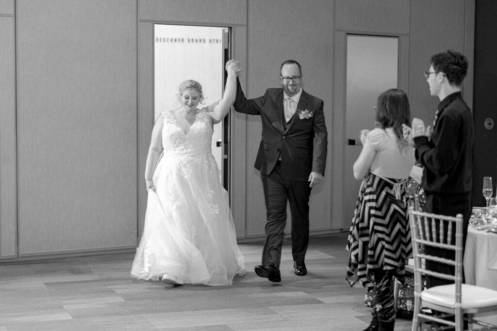 Black and white photo of the newlyweds making their grand entrance