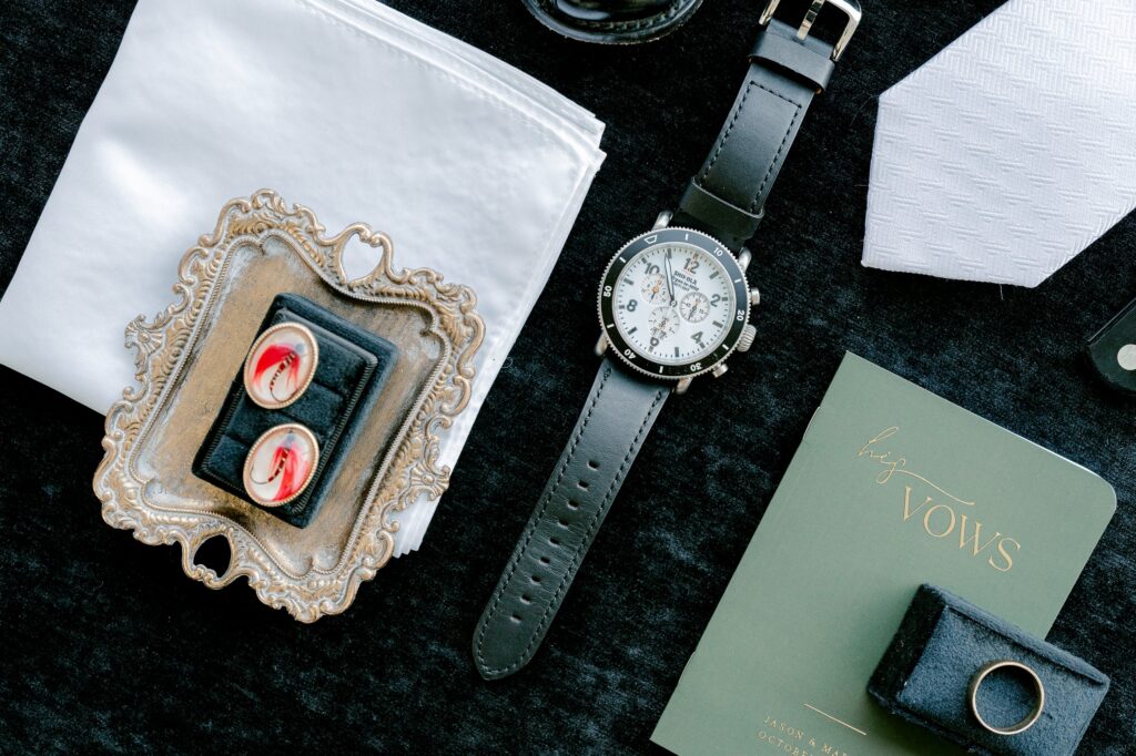 Groom's flat lay with his father's cufflinks, watch, tie and vow book