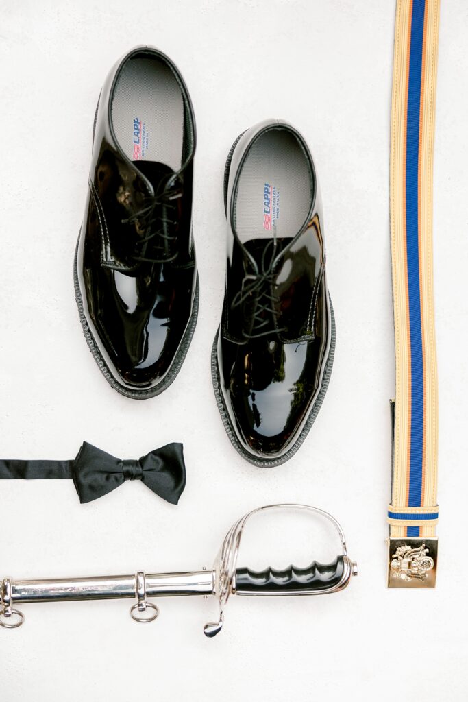 Groom details with polished shoes, bow tie and ceremonial saber