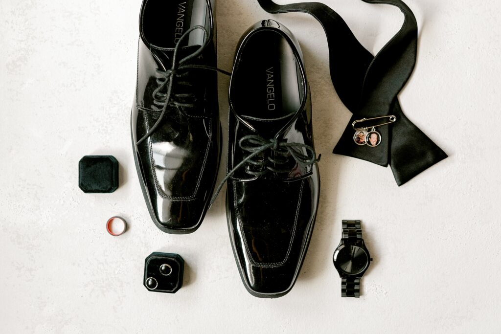 Groom details with black dress shoes, cufflinks and a watch