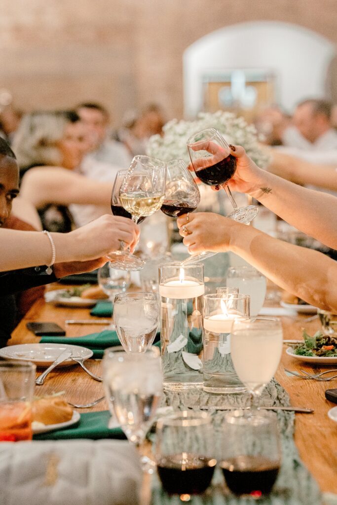 Guests toasting with wine glasses at the reception tables