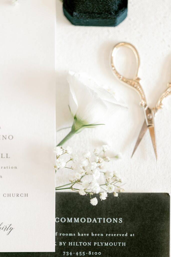 Invitation suite with gold scissors and white florals