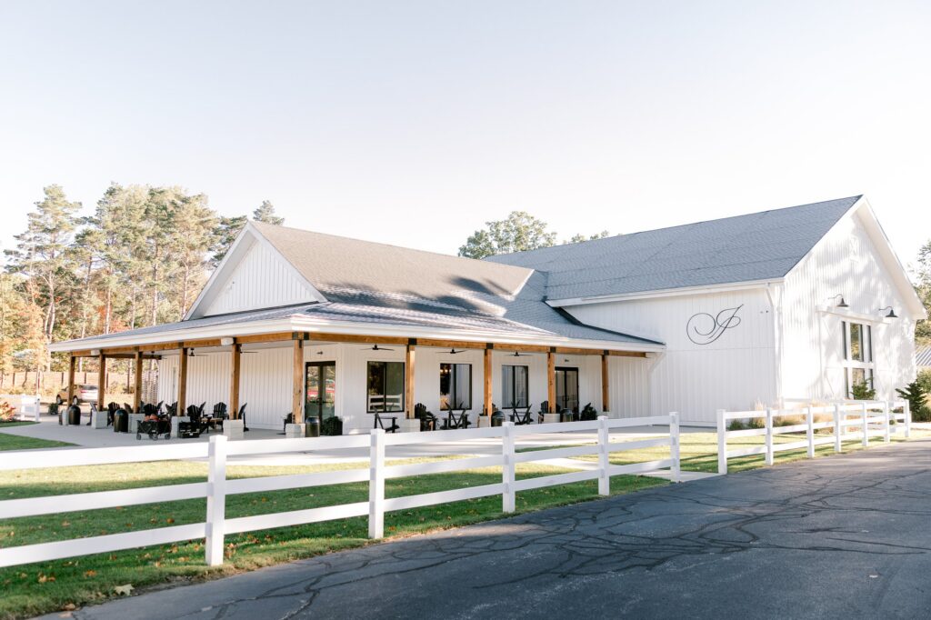 White event building at Ivy House in Saugatuck with a covered porch and white fence