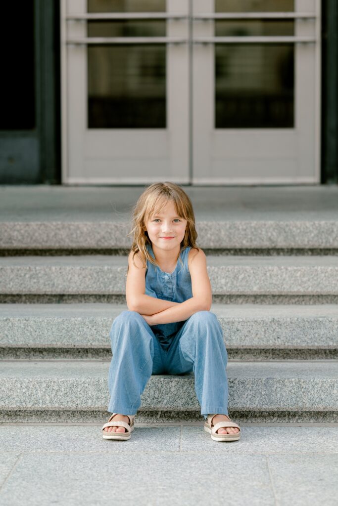 Girl sitting on the Civic Auditorium steps in front of the Art Deco doors in downtown Grand Rapids