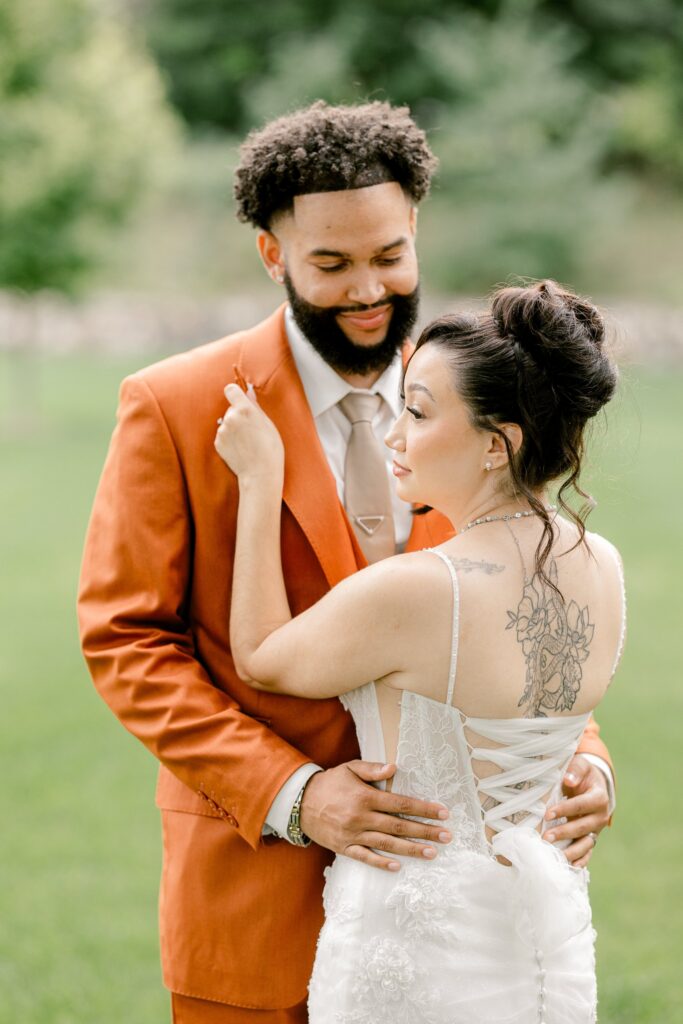 Bride and groom embracing on the lawn outside Leona Road