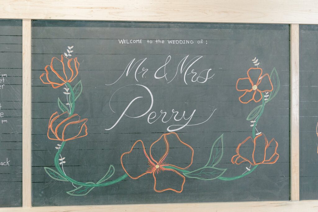 Hand-drawn chalkboard welcome sign for Mr. and Mrs. Perry at Leona Road, a former school in Grand Rapids