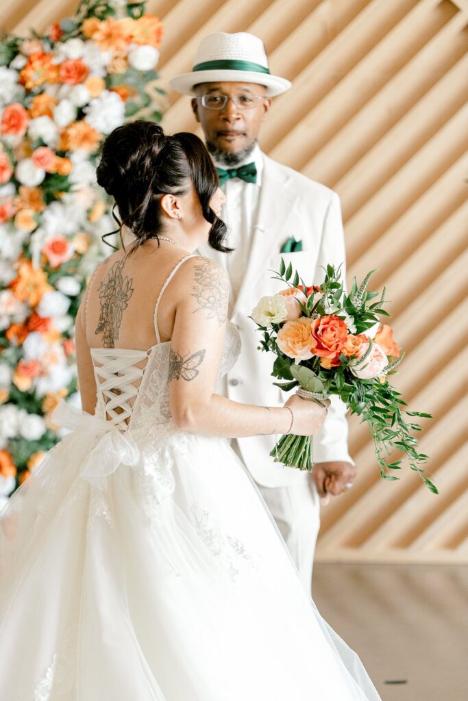 Bride sharing a first look with her father in front of the wood slat wall at Leona Road