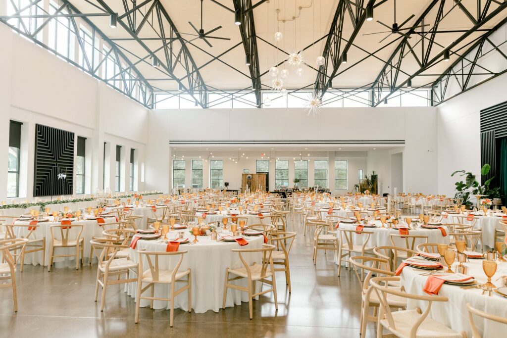 Leona Road reception hall set with round tables, skylights and exposed trusses