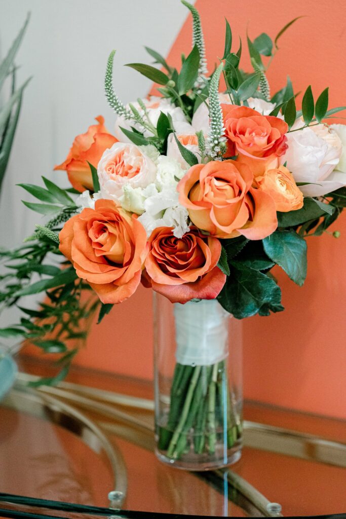 Bridal bouquet of orange and peach roses with greenery at Leona Road