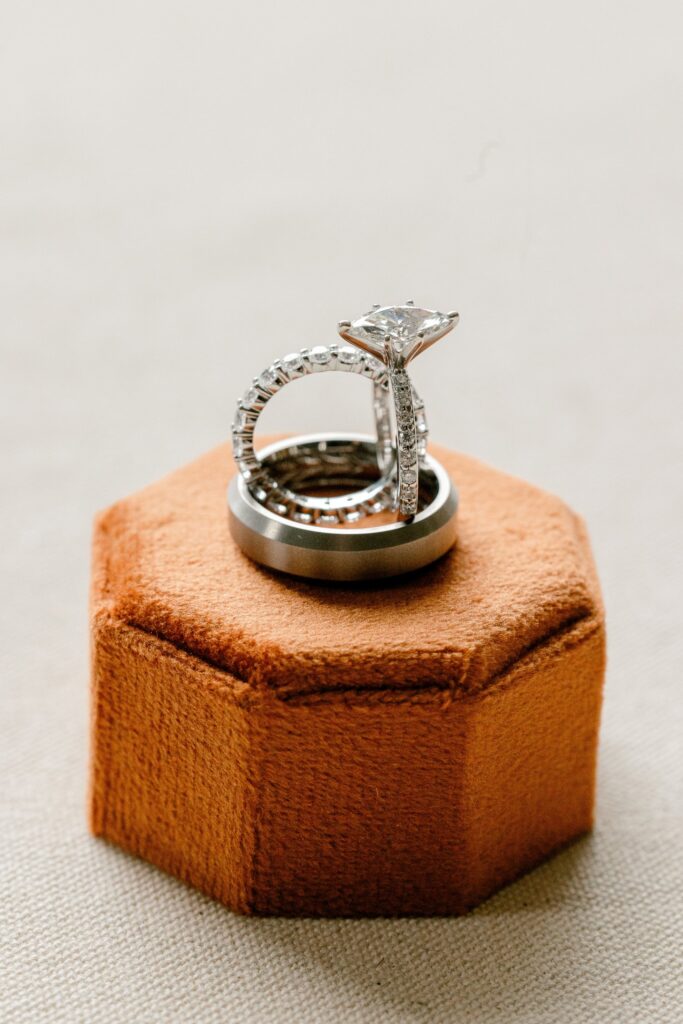 Wedding rings on a burnt orange velvet ring box at a Leona Road wedding in Grand Rapids