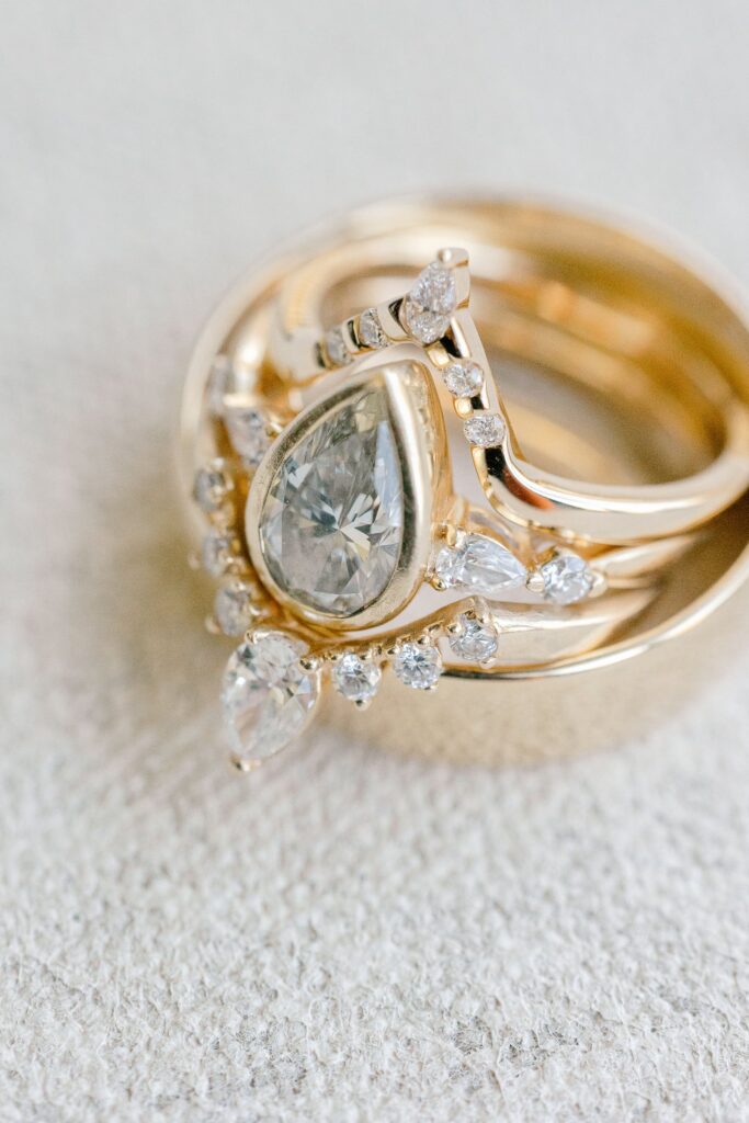 Pear shaped diamond engagement ring with a gold wedding band stack