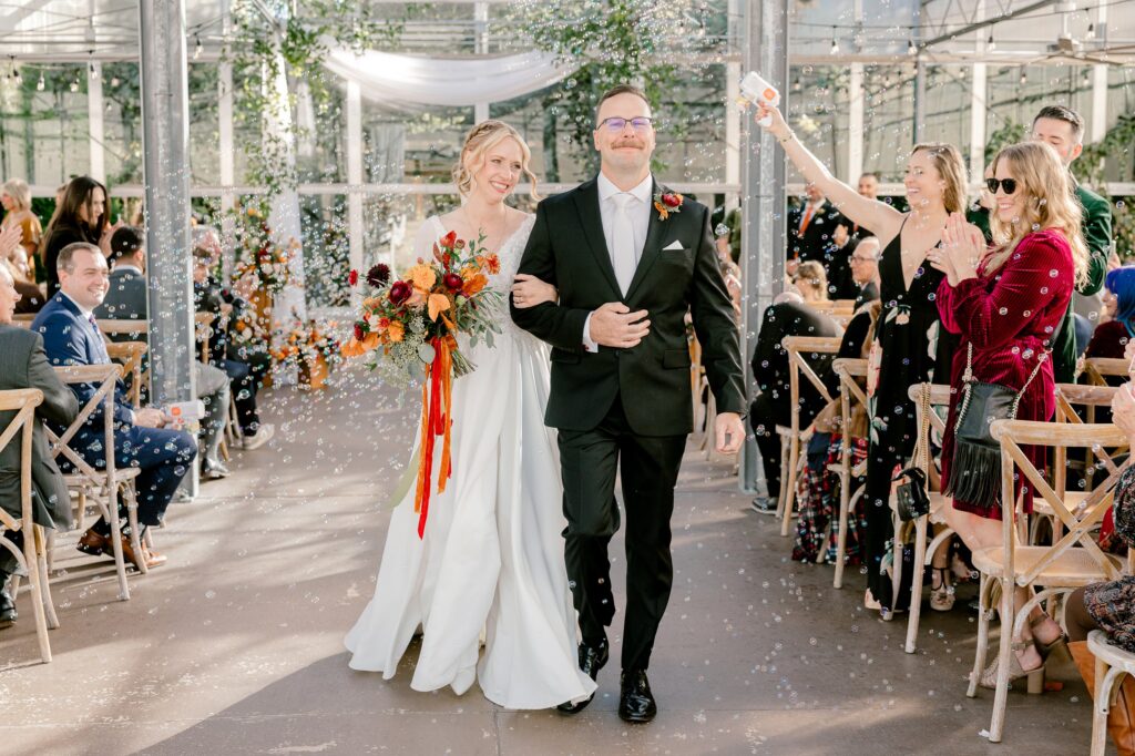 Bride and groom walking back up the aisle as guests cheer