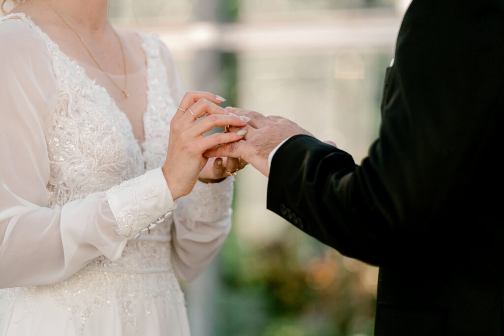 Groom placing the ring on the bride's finger