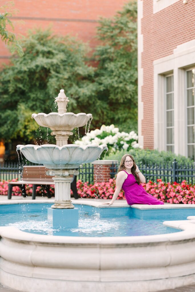 Senior girl sitting by a fountain in downtown Holland, Michigan